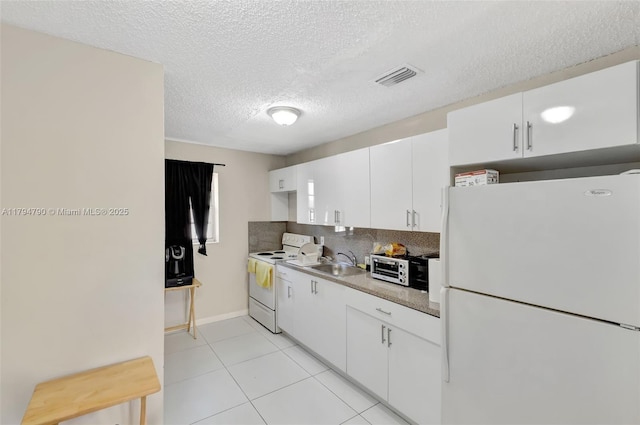 kitchen featuring white cabinets, a sink, white appliances, light tile patterned floors, and visible vents