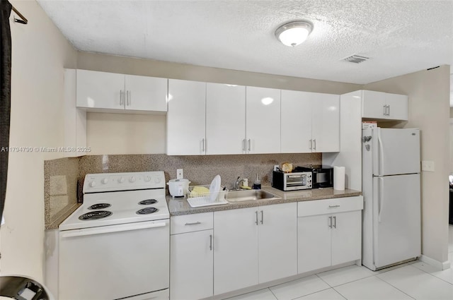 kitchen featuring white cabinets, a sink, white appliances, a textured ceiling, and visible vents