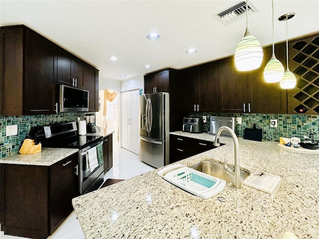 16541 Turquoise Trl, Weston, FL 33331 - kitchen featuring stainless steel appliances, decorative backsplash, hanging light fixtures, light stone counters, and recessed lighting