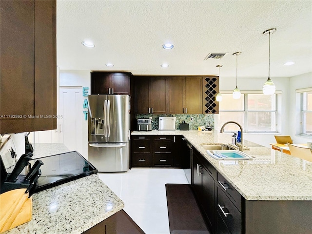 16541 Turquoise Trl, Weston, FL 33331 - kitchen with stainless steel refrigerator with ice dispenser, tasteful backsplash, a peninsula, light stone countertops, and pendant lighting