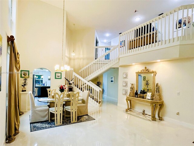 16541 Turquoise Trl, Weston, FL 33331 - dining room featuring a towering ceiling, arched walkways, tile patterned floors, stairway, and recessed lighting