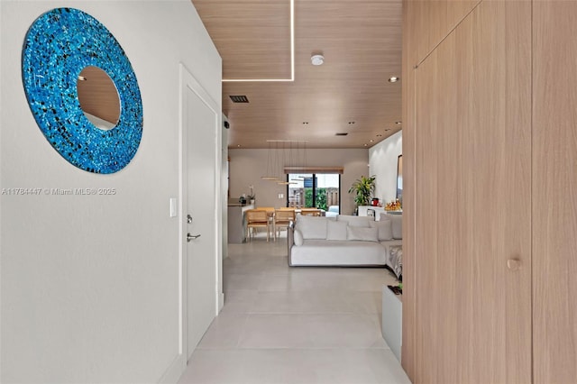 hall featuring visible vents, light tile patterned floors, and wooden ceiling