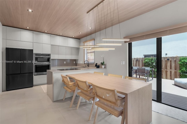 kitchen with double oven, modern cabinets, built in refrigerator, wood ceiling, and white cabinetry