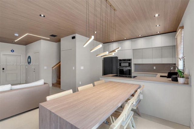 kitchen featuring visible vents, multiple ovens, recessed lighting, white cabinetry, and a sink
