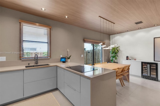 kitchen with a sink, wine cooler, black electric stovetop, and modern cabinets