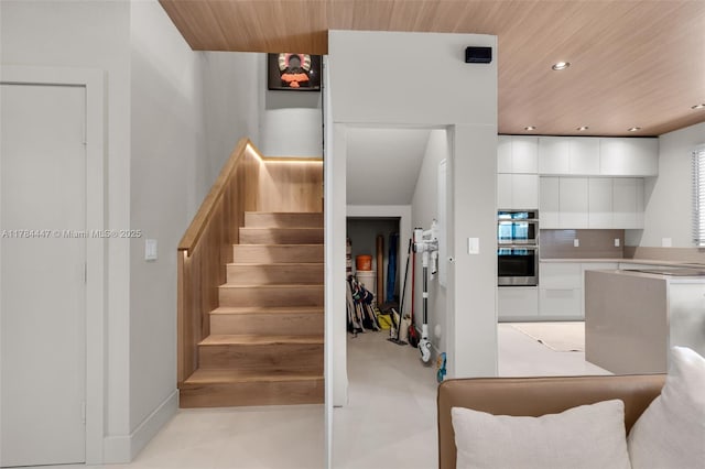 staircase with wood ceiling, baseboards, and recessed lighting