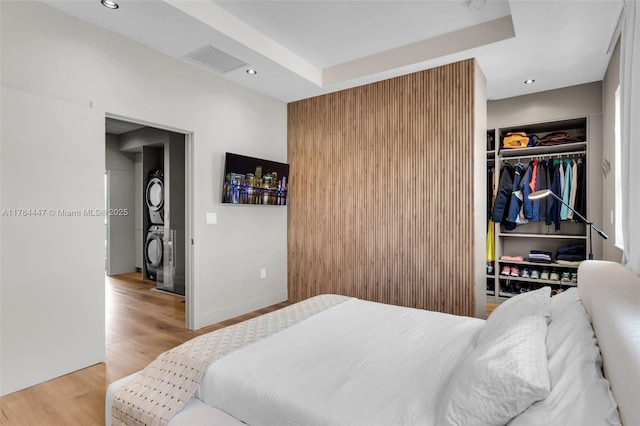 bedroom featuring recessed lighting, stacked washer / drying machine, visible vents, and light wood finished floors