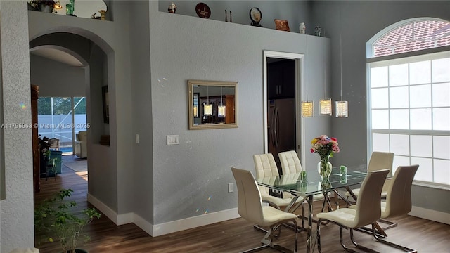 7310 NW 17th Ct, Pembroke Pines, FL 33024 - dining space featuring arched walkways, wood finished floors, healthy amount of natural light, and a textured wall