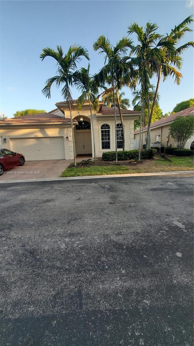 7310 NW 17th Ct, Pembroke Pines, FL 33024 - view of front facade featuring an attached garage, stucco siding, driveway, and a tiled roof