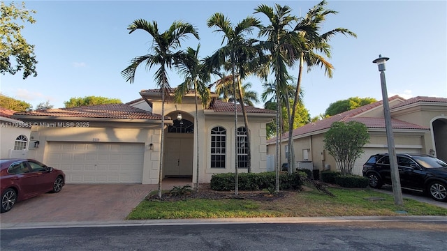 7310 NW 17th Ct, Pembroke Pines, FL 33024 - mediterranean / spanish-style home with stucco siding, a tiled roof, an attached garage, and driveway