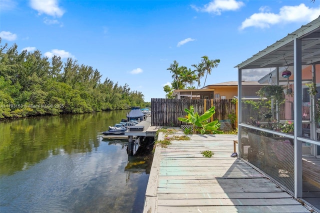 view of dock with a water view and fence