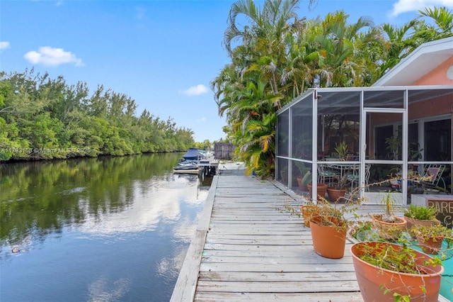 dock area featuring a water view and glass enclosure