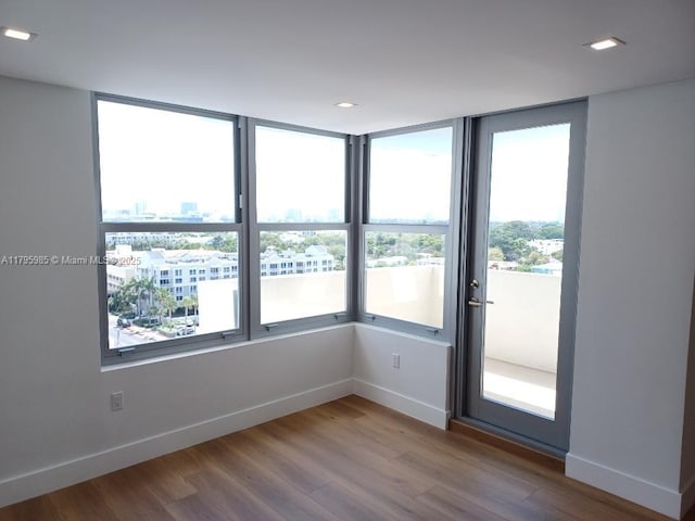 spare room featuring baseboards and wood finished floors