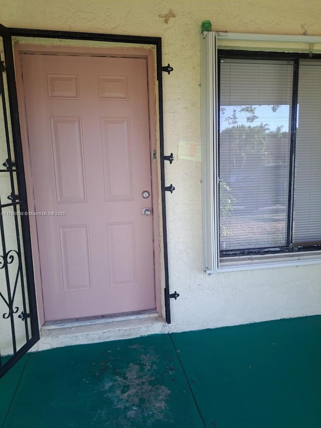 doorway to property featuring stucco siding