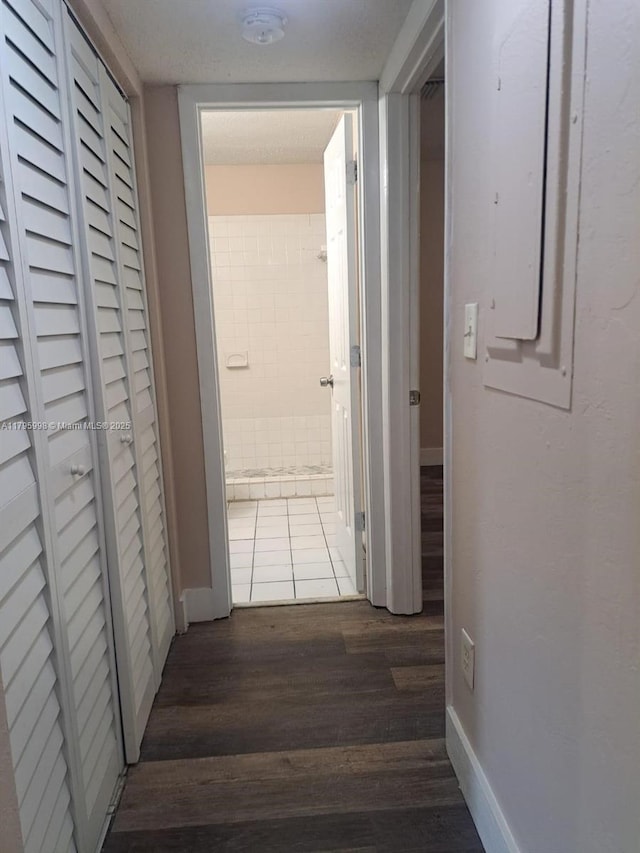 hall featuring baseboards and wood finished floors