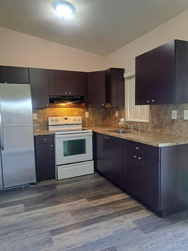 kitchen with a sink, white range with electric cooktop, freestanding refrigerator, and dark wood-type flooring