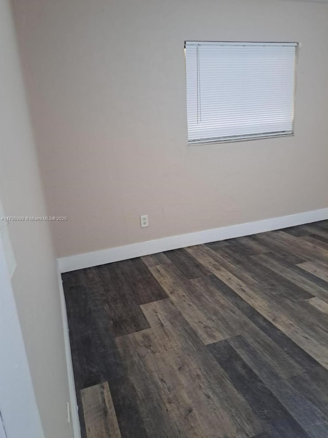 empty room featuring baseboards and wood finished floors