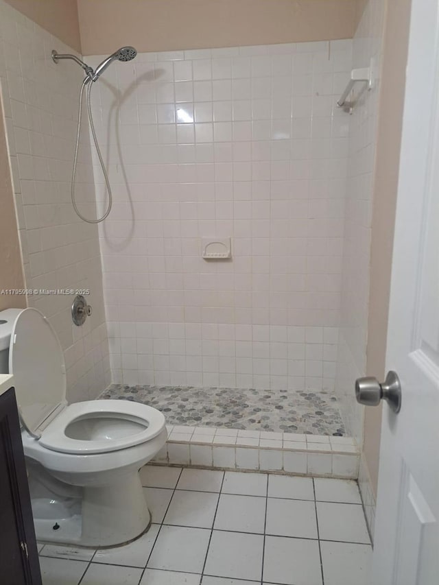 bathroom featuring tile patterned flooring, a stall shower, and toilet