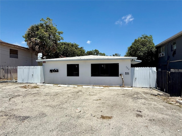 exterior space with fence, stucco siding, and uncovered parking