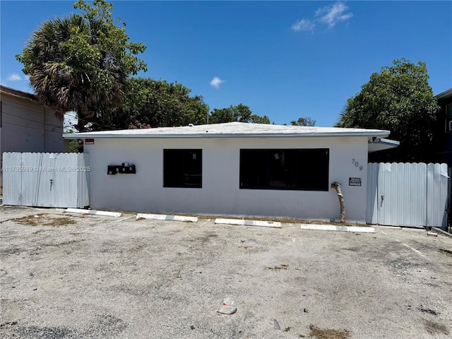 exterior space with fence, uncovered parking, and stucco siding