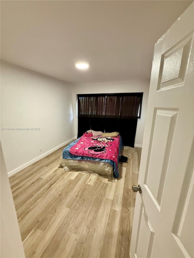 bedroom with baseboards and light wood-type flooring