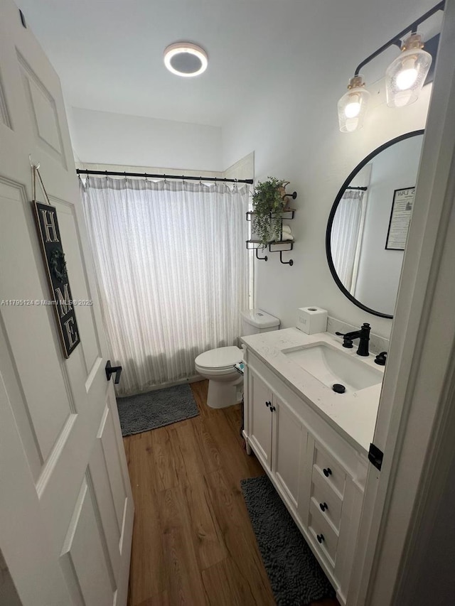 bathroom featuring vanity, a shower with curtain, toilet, and wood finished floors