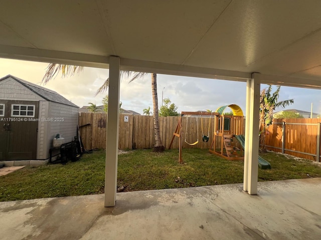 view of yard featuring a playground, a patio, and a fenced backyard