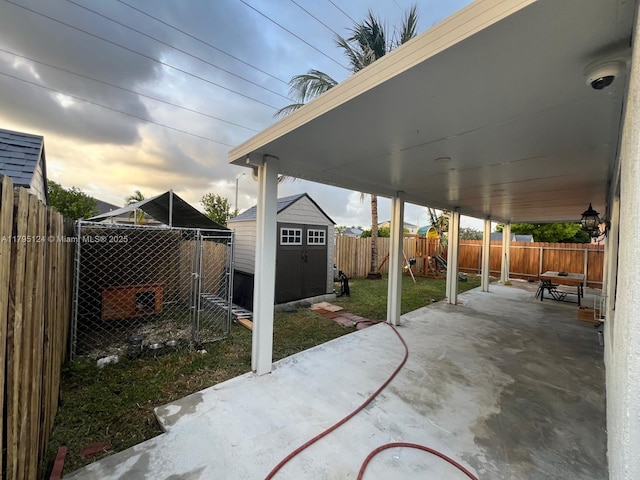 view of patio / terrace featuring a storage shed, an outdoor structure, and a fenced backyard