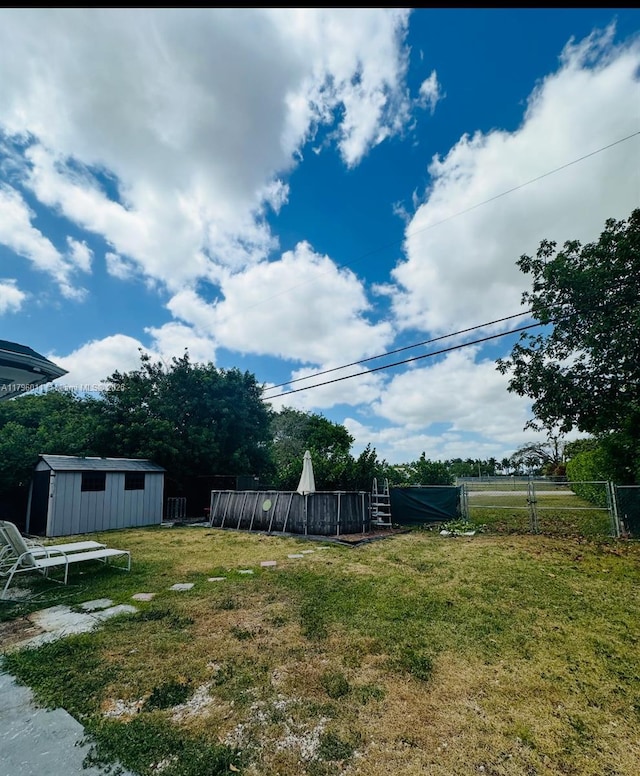 view of yard featuring fence, an outbuilding, and a storage unit