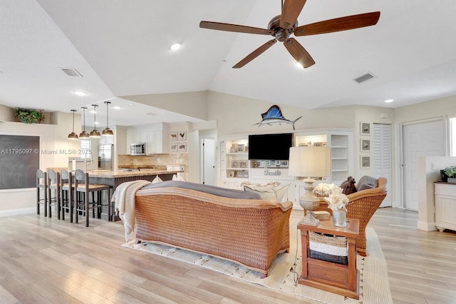 living room featuring ceiling fan, light wood finished floors, vaulted ceiling, recessed lighting, and baseboards