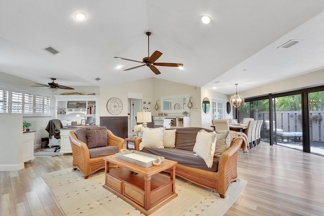 living room with ceiling fan, light wood-type flooring, and vaulted ceiling