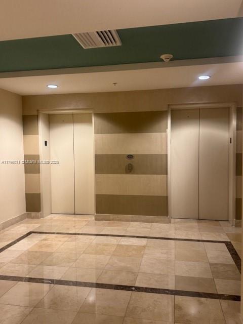 hallway with recessed lighting, elevator, and visible vents