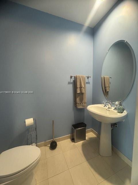 bathroom featuring toilet, baseboards, and tile patterned floors