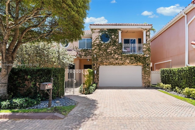 3710 NE 208th Ter, Aventura, FL 33180 - view of front of home featuring a balcony, an attached garage, decorative driveway, stucco siding, and fence
