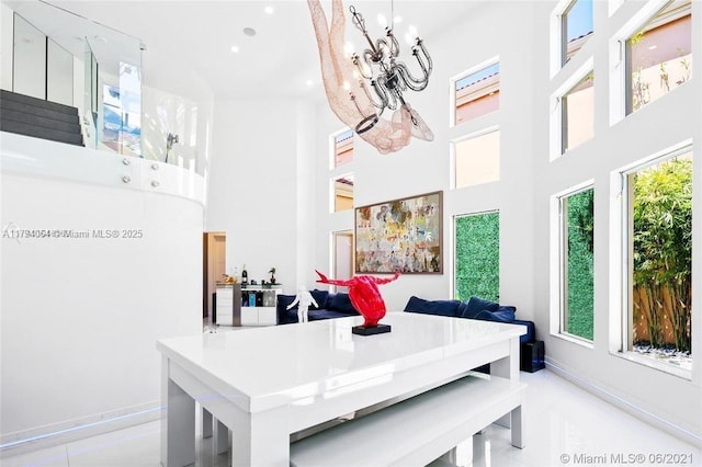 dining area with baseboards, recessed lighting, and a towering ceiling