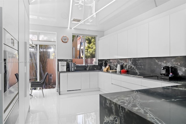 3710 NE 208th Ter, Aventura, FL 33180 - kitchen with modern cabinets, black electric cooktop, decorative backsplash, white cabinetry, and a sink