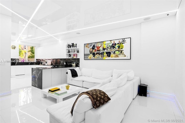 living room featuring tile patterned floors and baseboards