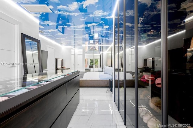 interior space featuring connected bathroom, marble finish floor, and vanity
