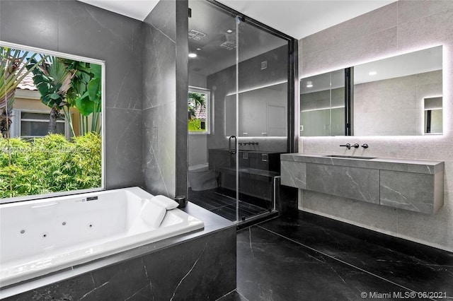 full bathroom with vanity, a whirlpool tub, toilet, and a stall shower