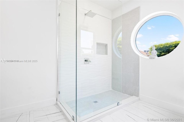 full bath with baseboards, a shower stall, and marble finish floor