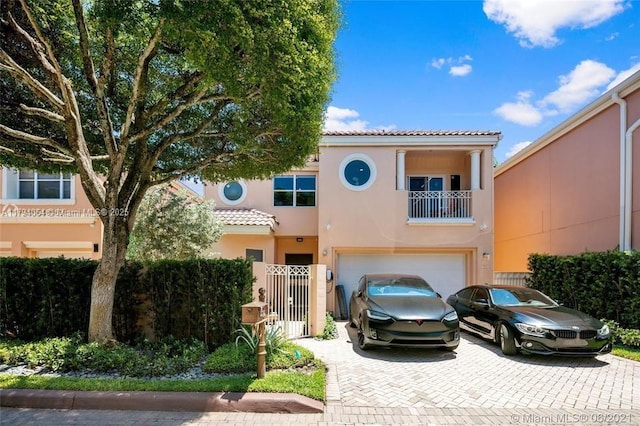 view of front of home with a tiled roof, decorative driveway, a garage, and stucco siding