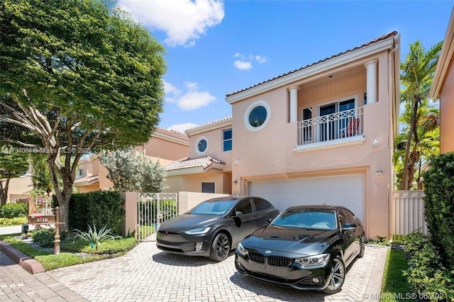 mediterranean / spanish-style house with decorative driveway, stucco siding, and a tiled roof