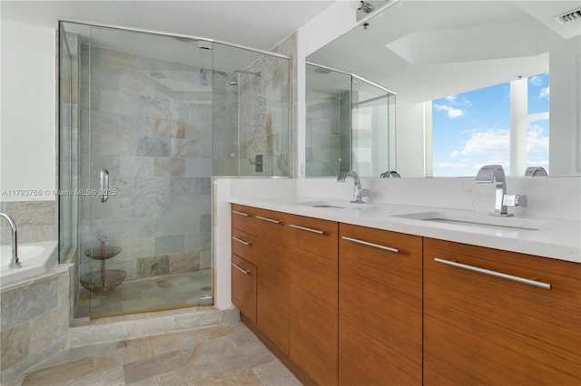 full bathroom featuring a sink, double vanity, and a shower stall