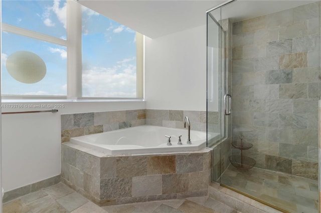 bathroom featuring a shower stall and a bath