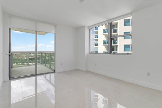 unfurnished room featuring tile patterned floors and baseboards