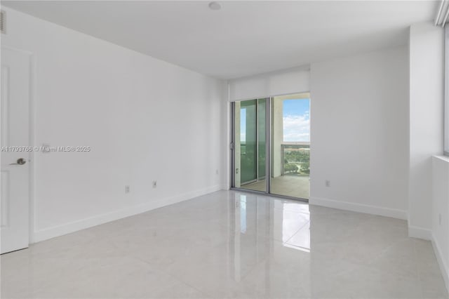 empty room with baseboards, light tile patterned floors, and visible vents
