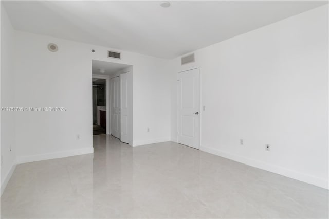 spare room with baseboards, light tile patterned floors, and visible vents