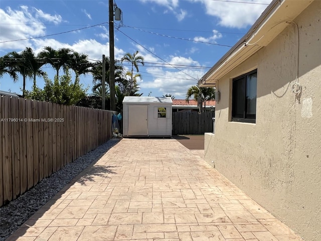 view of patio / terrace featuring a storage unit, an outdoor structure, and a fenced backyard
