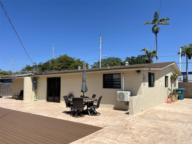 rear view of property featuring a patio, fence, ac unit, and stucco siding