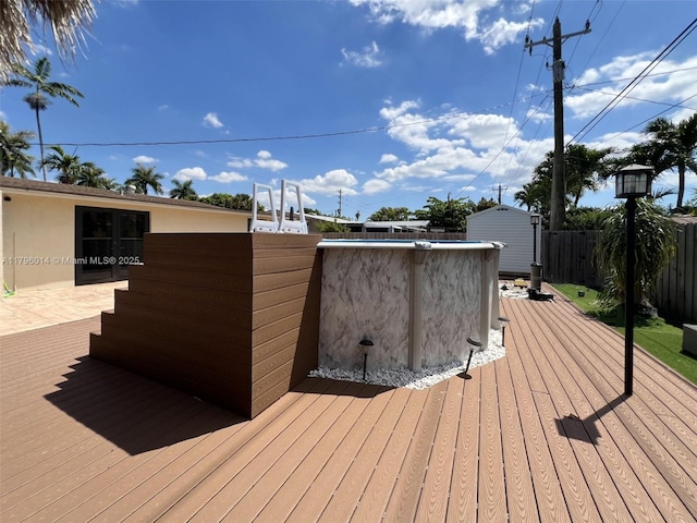 deck with fence, an outdoor structure, and a storage unit